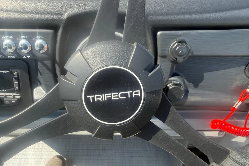 Slide: The Image of Steering wheel of 2026 Trifecta 22RFCS3 boat with control panel and switches. - 11