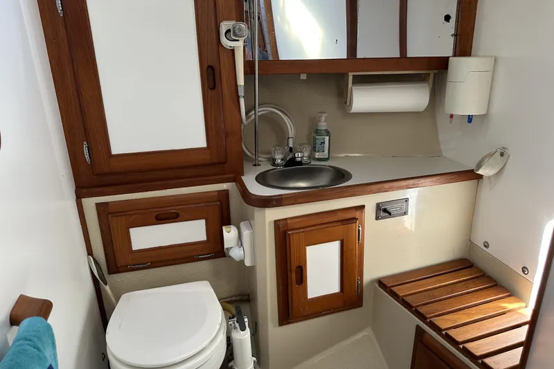 Slide: The Image of Catalina 36 MkII 1985 yacht bathroom with wooden cabinets, sink, and toilet. - 16