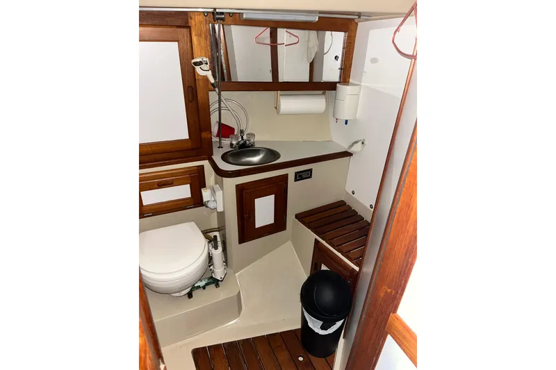 Slide: The Image of Compact bathroom in a 1985 Catalina 36 MkII sailboat with wooden accents and stainless steel sink. - 7