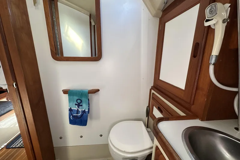 Slide: The Image of Interior of 1985 Catalina 36 MkII yacht bathroom with wooden cabinetry and nautical-themed towel. - 17