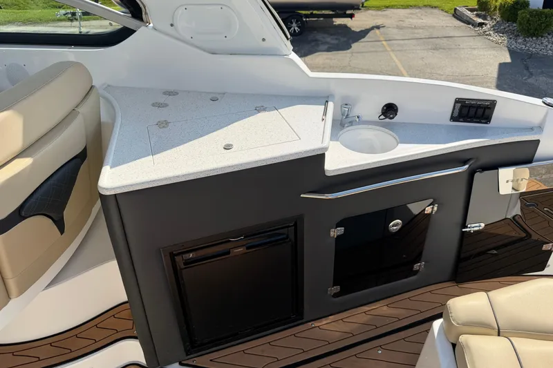 Slide: The Image of 2019 Rinker EX 320 boat interior with kitchenette and seating area. - 12