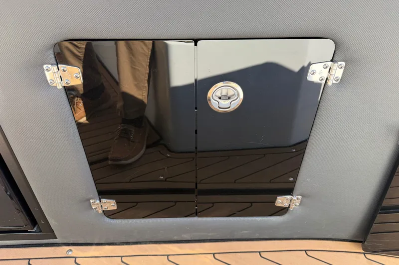 Slide: The Image of 2019 Rinker EX 320 boat compartment door with chrome hinges and handle. - 13