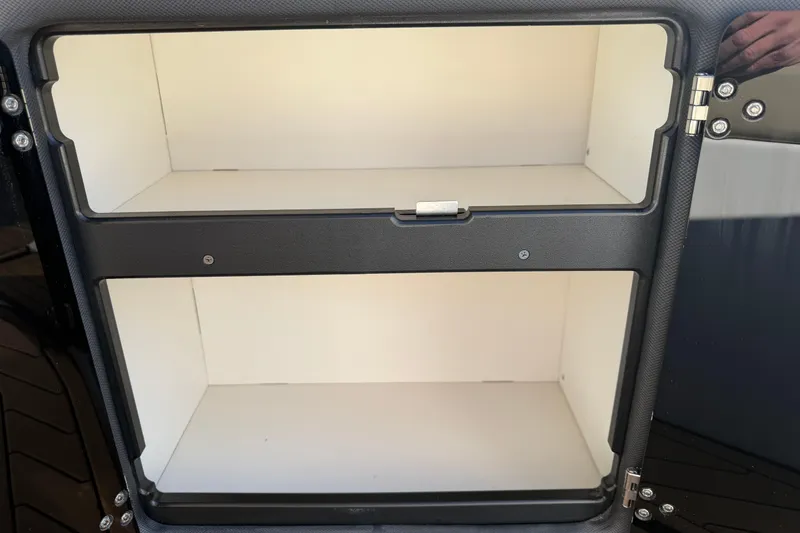 Slide: The Image of 2019 Rinker EX 320 storage compartment with open shelves and secure latch. - 14