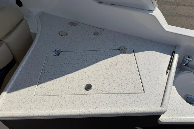 Slide: The Image of 2019 Rinker EX 320 boat interior with speckled countertop and storage hatch. - 17