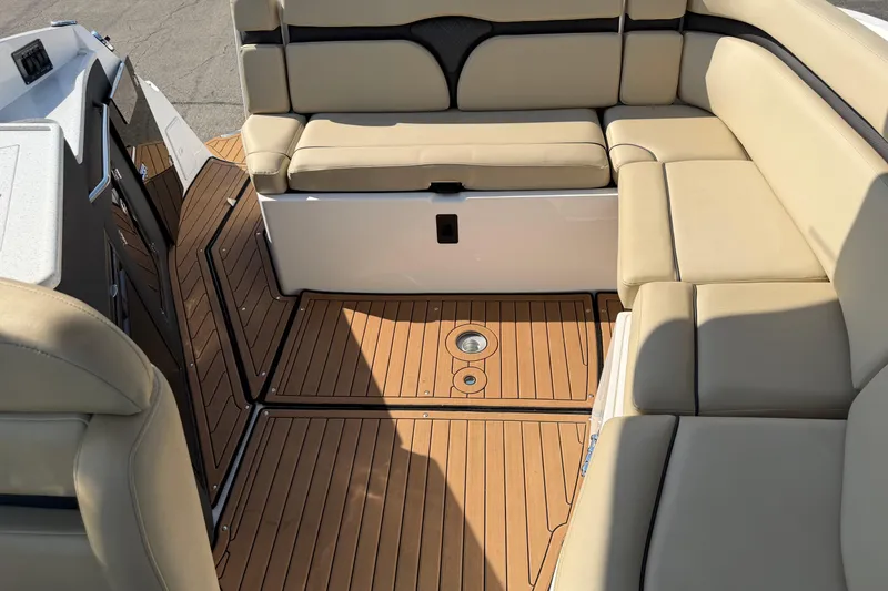 Slide: The Image of 2019 Rinker EX 320 boat interior with beige seating and wooden flooring. - 4