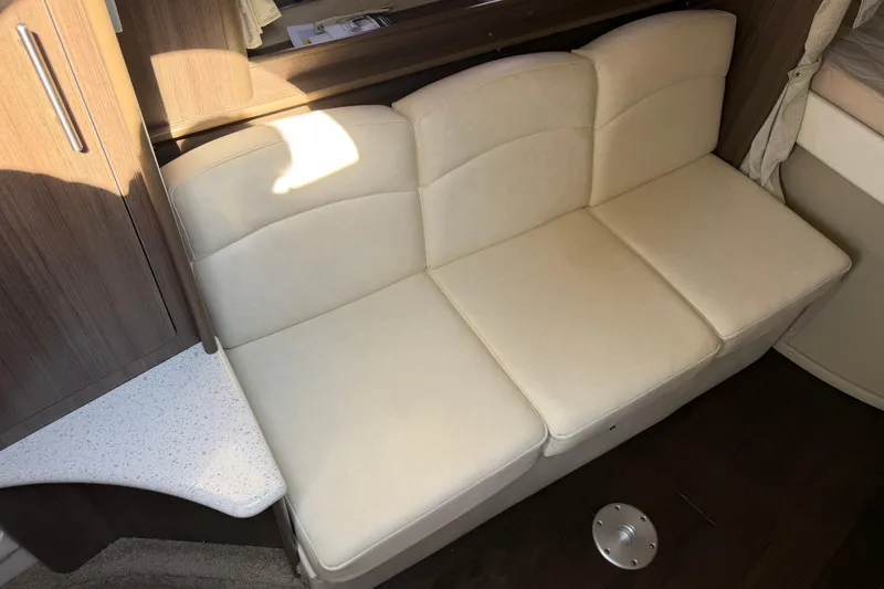 Slide: The Image of 2019 Rinker EX 320 interior showing a wooden wardrobe and bed area. - 43