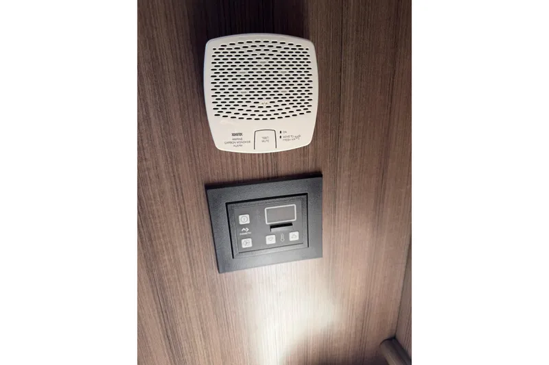 Slide: The Image of 2019 Rinker EX 320 cabin with carbon monoxide alarm and control panel on wooden wall. - 52