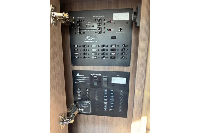 Slide: The Image of Electrical control panel of a 2019 Rinker EX 320 boat, featuring generator and shore power switches. - 53