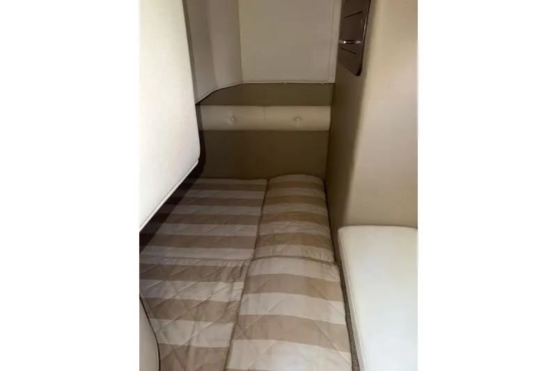 Slide: The Image of Interior cabin of 2019 Rinker EX 320 boat with beige quilted bedding. - 56