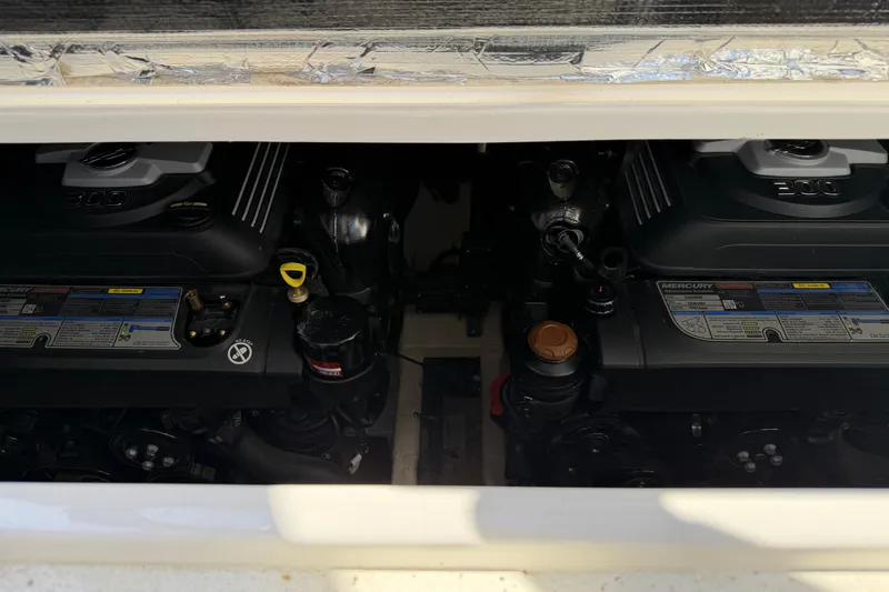 Slide: The Image of 2019 Rinker EX 320 boat engine compartment with dual Mercury engines. - 58