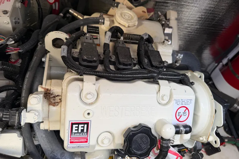 Slide: The Image of Engine compartment of a 2019 Rinker EX 320 boat, featuring EFI system components. - 61