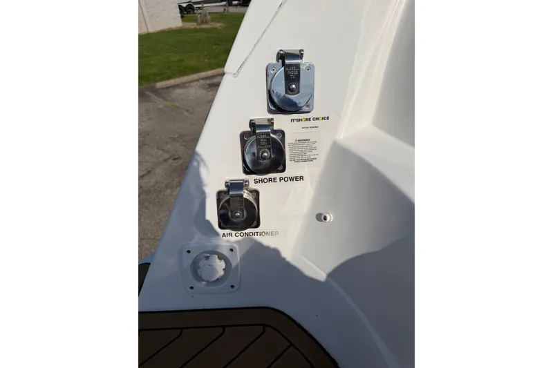 Slide: The Image of 2019 Rinker EX 320 boat power connections: shore power and air conditioner outlets. - 63