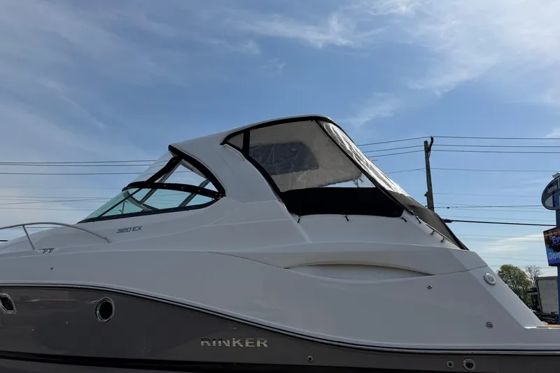 Slide: The Image of 2019 Rinker EX 320 boat with sleek design against a clear sky. - 71