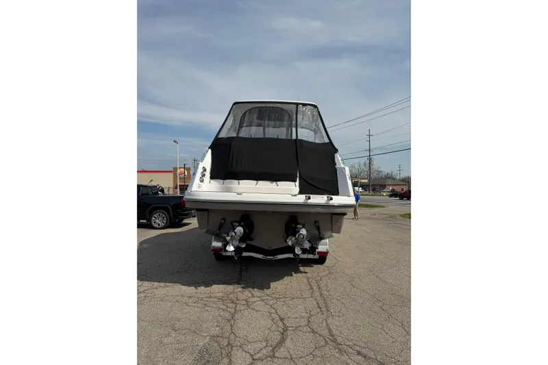 Slide: The Image of 2019 Rinker EX 320 boat rear view with covered cockpit and dual propellers. - 72