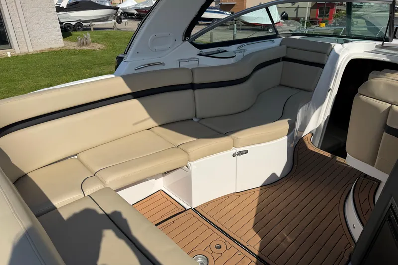 Slide: The Image of 2019 Rinker EX 320 boat interior with beige seating and teak flooring. - 8