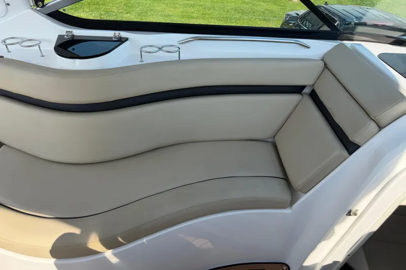 Slide: The Image of Luxurious seating on a 2019 Rinker EX 320 boat, featuring beige upholstery and cup holders. - 9