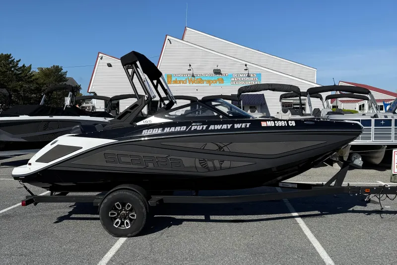 The Image of 2024 Scarab 195 ID boat on trailer at watersports dealership. - 1