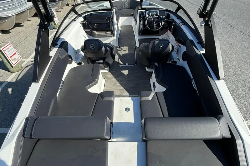 Slide: The Image of 2024 Scarab 195 ID boat interior with seating and steering wheel, docked outdoors. - 11