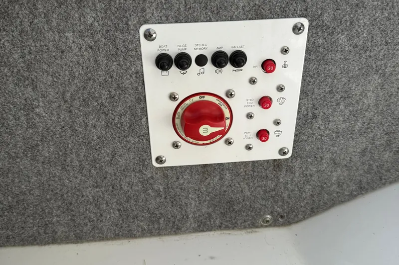 Slide: The Image of Control panel of a 2024 Scarab 195 ID boat with switches and red dial. - 16