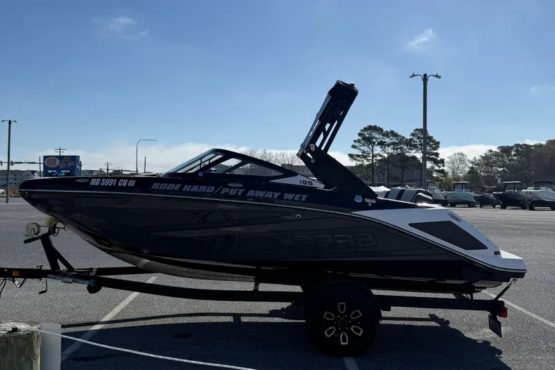 Slide: The Image of 2024 Scarab 195 ID boat on trailer in parking lot, side view. - 5