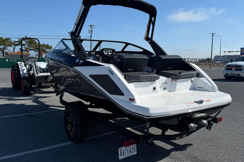 Slide: The Image of 2024 Scarab 195 ID boat on trailer, parked outdoors, rear view. - 6
