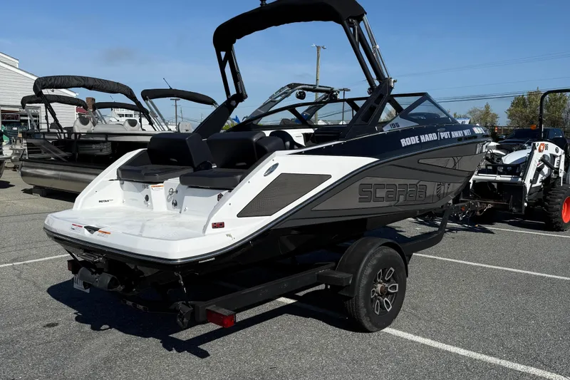 Slide: The Image of 2024 Scarab 195 ID boat on trailer in parking lot, rear view. - 8