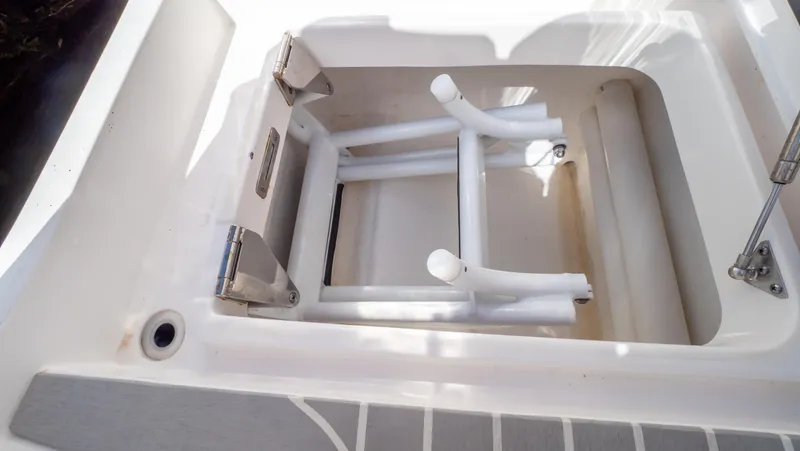 Slide: The Image of 2022 Intrepid 345 Valor boat storage compartment with white interior and metal hinges. - 42