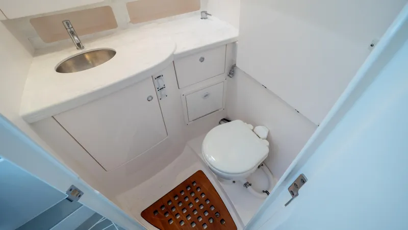 Slide: The Image of 2022 Intrepid 345 Valor boat bathroom with sink, toilet, and wooden floor mat. - 7