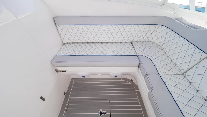 Slide: The Image of 2022 Intrepid 345 Valor boat interior with white cushioned seating and sleek flooring. - 9