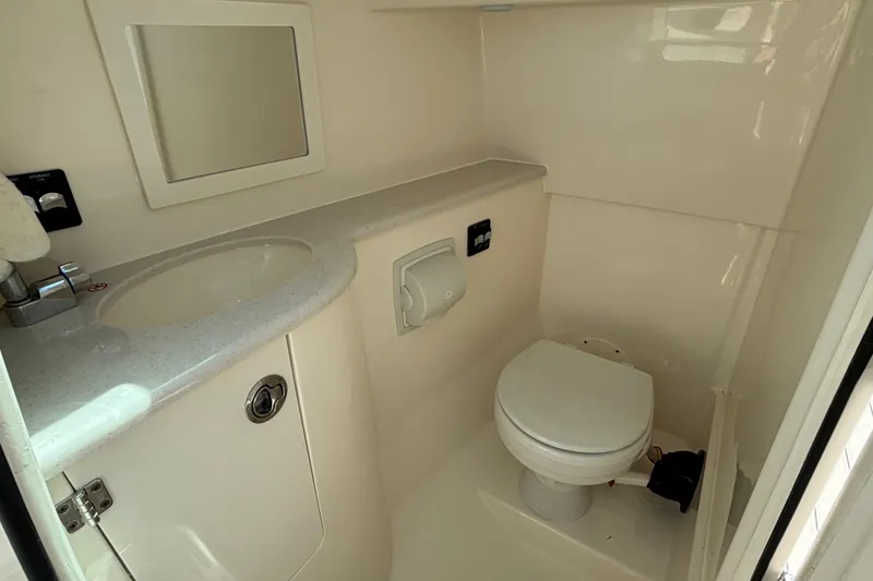 Slide: The Image of 2023 Cobia 280 Dual Console boat bathroom with sink, mirror, and toilet. - 10