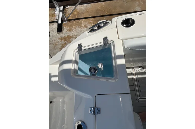 Slide: The Image of 2023 Cobia 280 Dual Console boat interior with livewell and cup holder. - 12