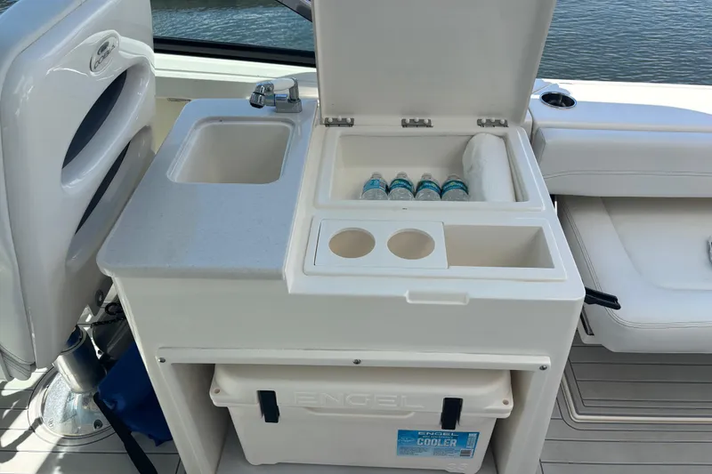 Slide: The Image of 2023 Cobia 280 Dual Console boat with sink, cooler, and storage area. - 16