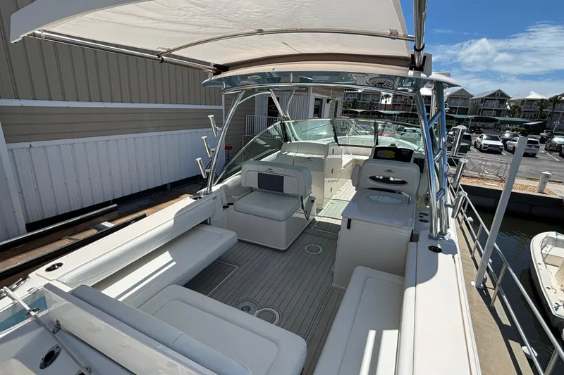 Slide: The Image of 2023 Cobia 280 Dual Console boat with spacious seating and modern amenities at a dock. - 17