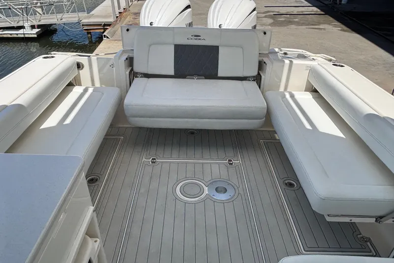 Slide: The Image of 2023 Cobia 280 Dual Console boat interior with cushioned seating and deck view. - 18