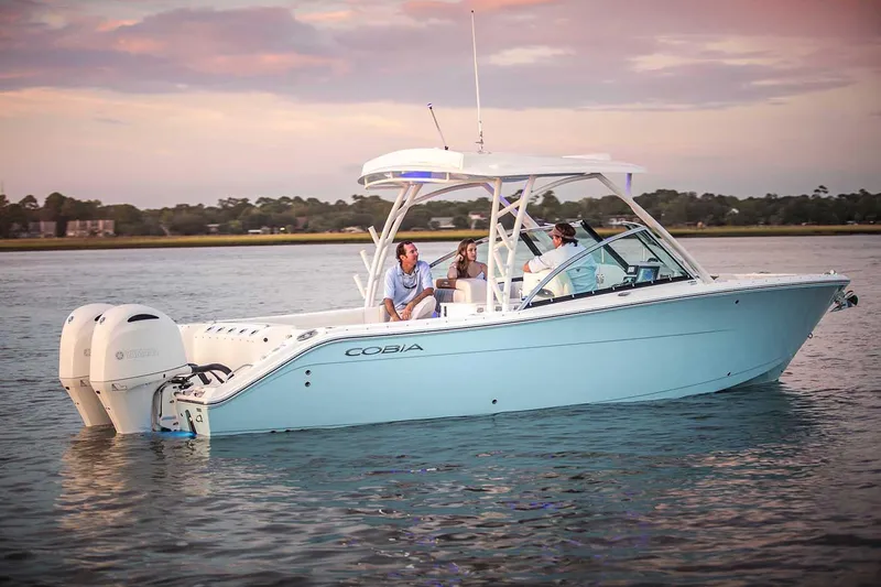Slide: The Image of Manufacturer Provided Image: 2023 Cobia 280 Dual Console boat on calm water at sunset. - 24
