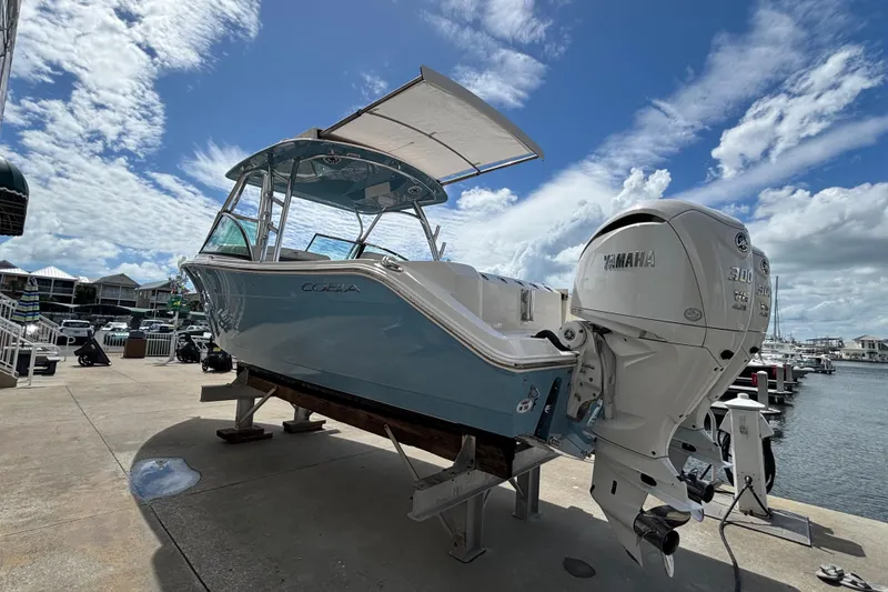 Slide: The Image of 2023 Cobia 280 Dual Console boat with Yamaha engine docked by the marina. - 3