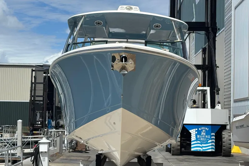 Slide: The Image of 2023 Cobia 280 Dual Console boat docked at a marina, front view. - 4