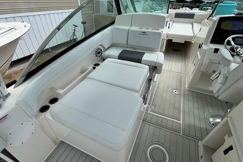 Slide: The Image of 2023 Cobia 280 Dual Console boat interior with cushioned seating and modern dashboard. - 5