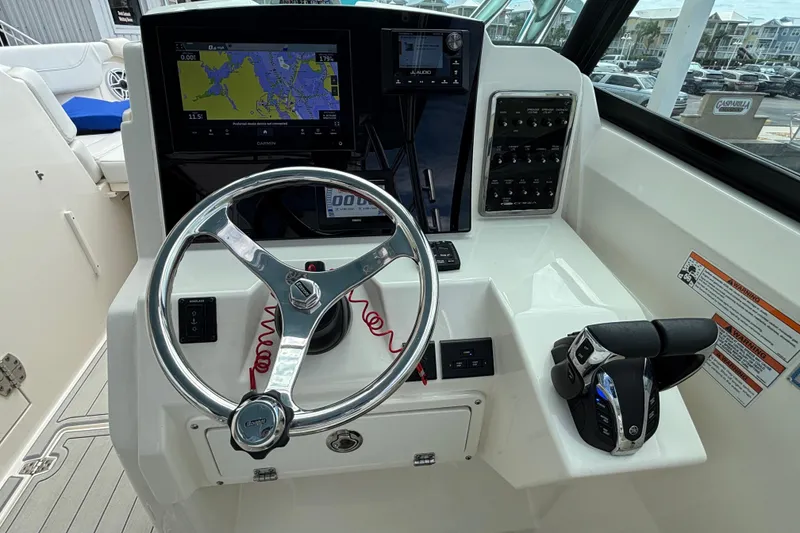 Slide: The Image of 2023 Cobia 280 Dual Console boat dashboard with steering wheel and navigation system. - 6