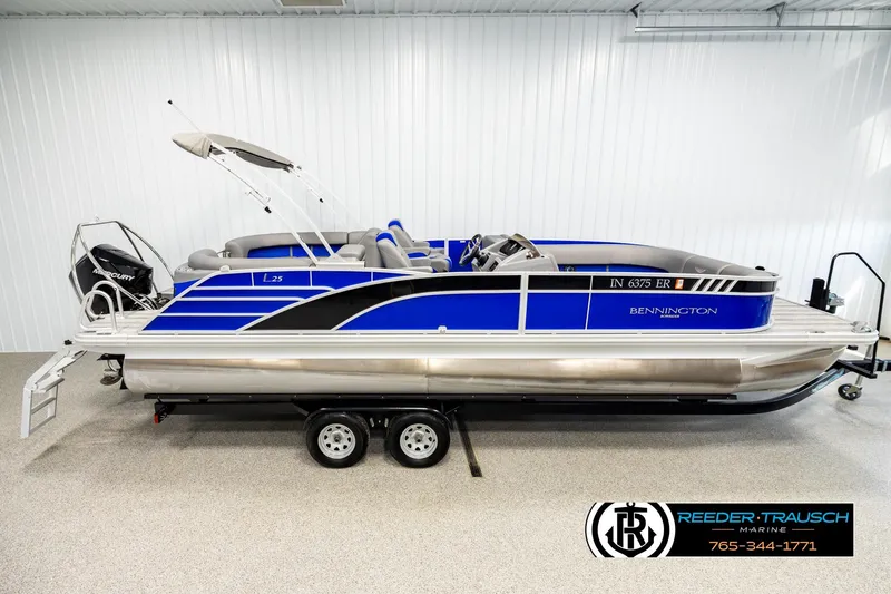 The Image of 2025 Bennington LTFBSE pontoon boat in showroom, featuring sleek blue design and modern amenities. - 1