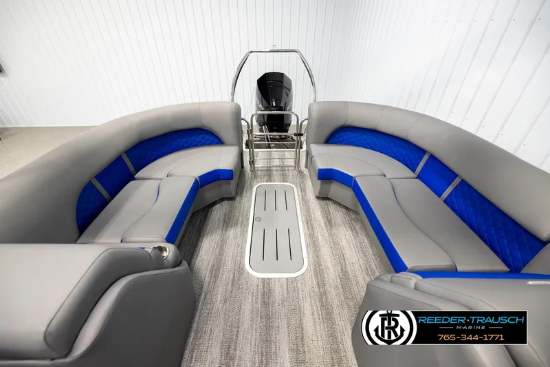 Slide: The Image of 2025 Bennington LTFBSE pontoon boat interior with gray and blue seating, Reeder-Trausch Marine logo. - 15