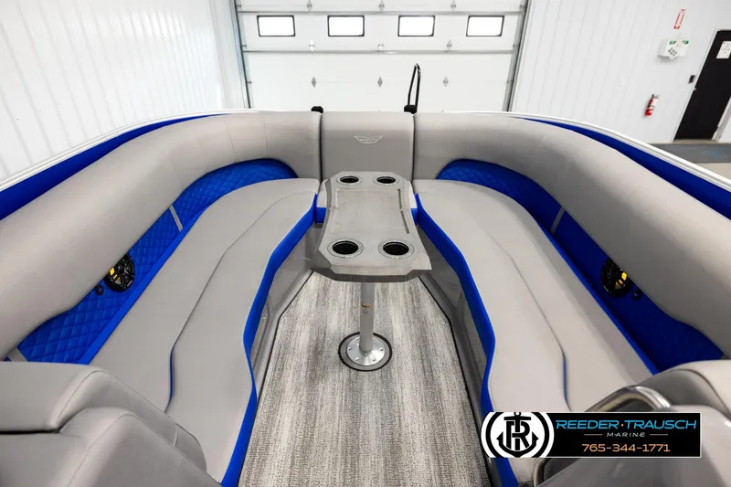 Slide: The Image of 2025 Bennington LTFBSE boat interior with gray and blue seating, central table, and cup holders. - 19