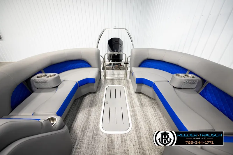 Slide: The Image of 2025 Bennington LTFBSE pontoon boat interior with gray and blue seating, cup holders, and steering console. - 20