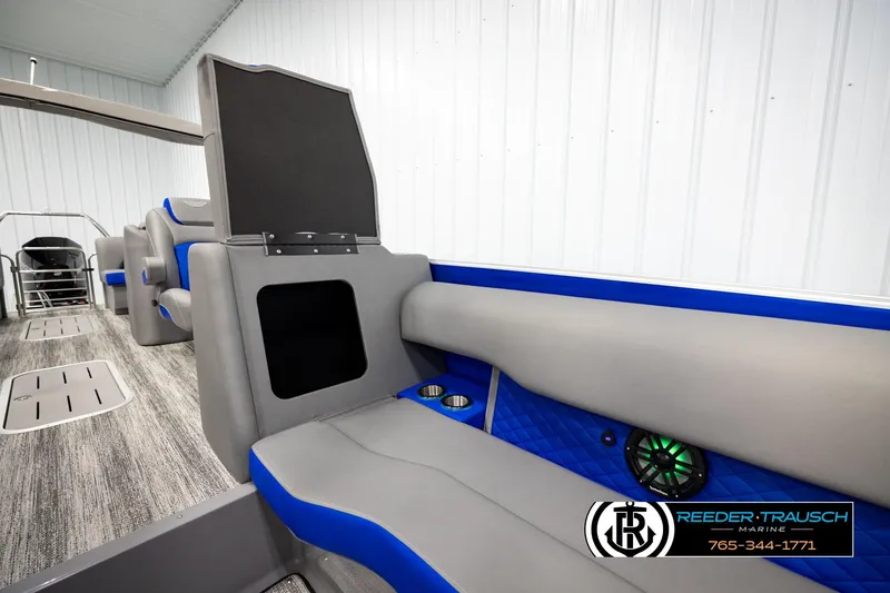 Slide: The Image of 2025 Bennington LTFBSE boat interior with gray and blue seating, cup holders, and speaker system. - 24
