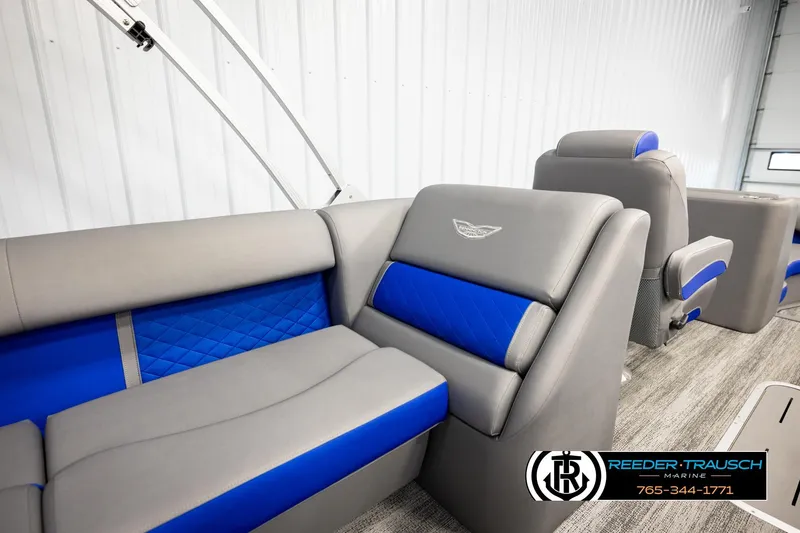 Slide: The Image of 2025 Bennington LTFBSE boat interior with gray and blue seating, Reeder-Trausch Marine logo. - 27