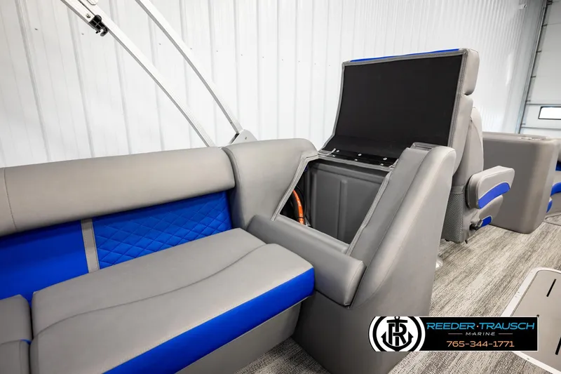 Slide: The Image of 2025 Bennington LTFBSE boat interior with gray and blue seating, storage compartment open. - 28