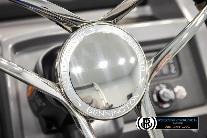 Slide: The Image of Steering wheel of 2025 Bennington LTFBSE boat, featuring chrome details and brand logo. - 31