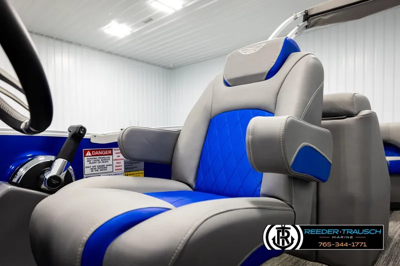 Slide: The Image of 2025 Bennington LTFBSE boat interior with blue and gray captain's chair, steering wheel, and controls. - 38
