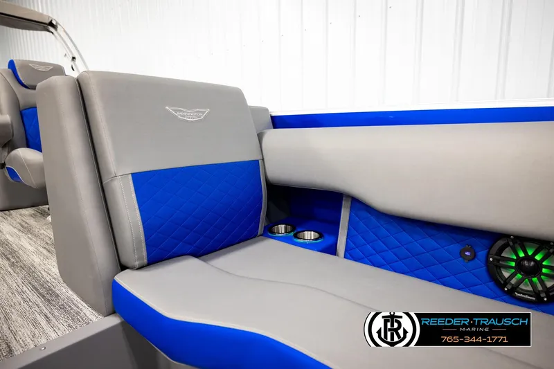 Slide: The Image of 2025 Bennington LTFBSE boat interior with blue and gray seating, cup holders, and speaker. - 40