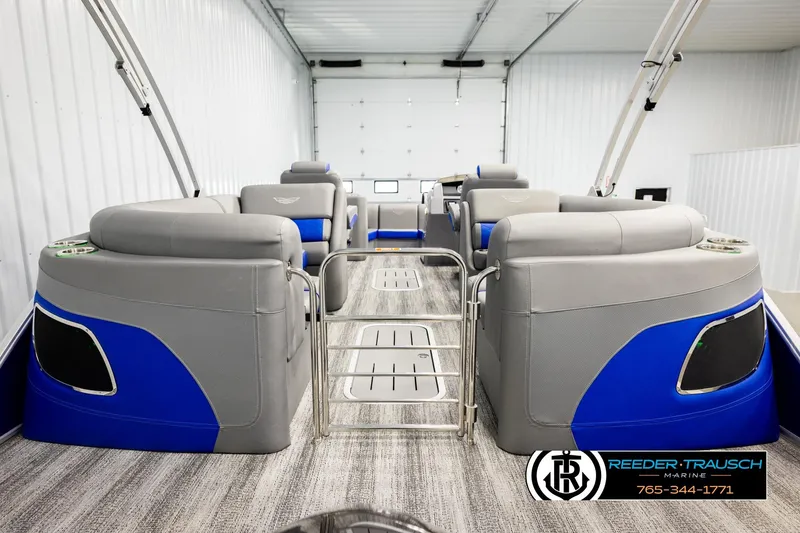 Slide: The Image of 2025 Bennington LTFBSE pontoon boat interior with gray and blue seating in a showroom. - 44